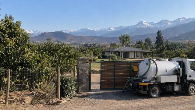 Parcela con paltos en el valle de Aconcagua y un camión limpia fosas junto al portón